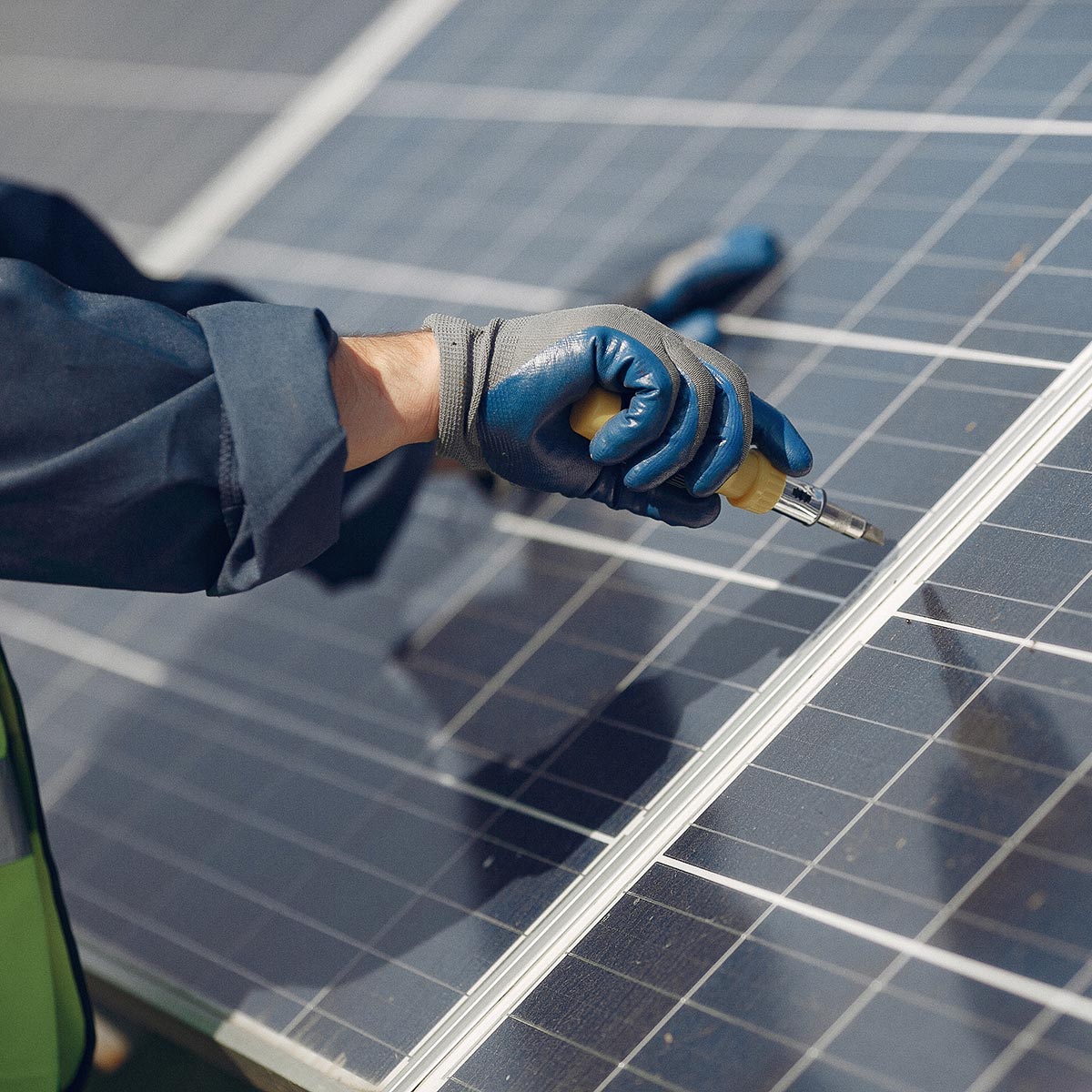 Man in a white helmet near a solar panel